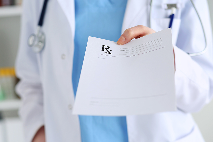 doctor handing rx paper to medical resident who is a home owner